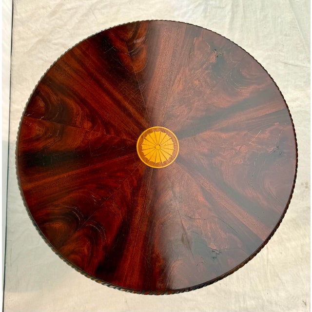 This traditional pedestal table features a beautiful flame mahogany veneer top arranged in a sunburst pattern and centered...