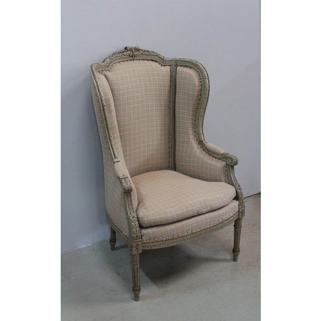 Louis XVI style wing chair. Its frame, sculpted on all its visible sides, displays a decoration of rose buds in the upper...