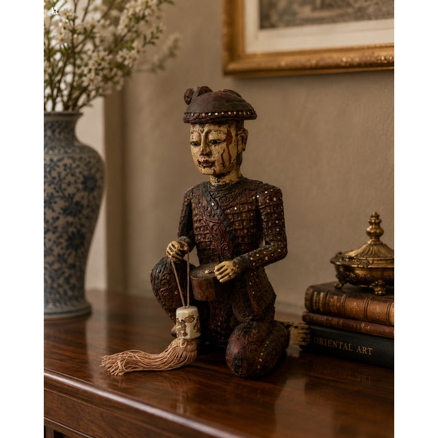 Polychrome Wood with Gilt Accents | 20th Century This expressive hand-carved Chinese figural sculpture depicts a seated...