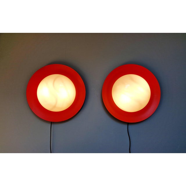 Pair of xxl space age wall sconces, round in orange lacquered metal (original color) with white opaline glass shades,...