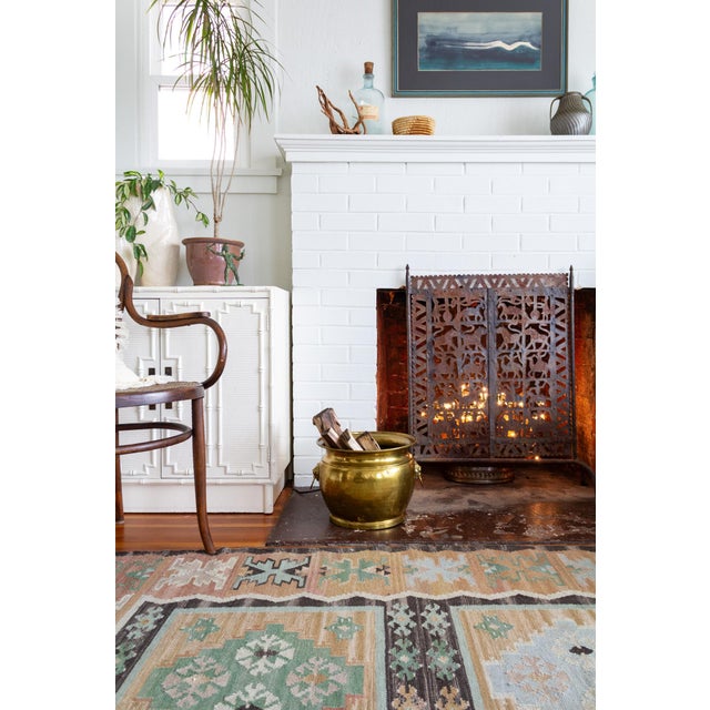 This brass-plated cachepot features rings on the sides, mounted in the mouths of lion heads, nodding to classical European...