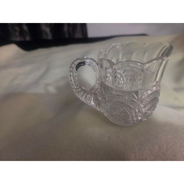 Early American Pattern Glass (EAPG) creamer pitcher, produced by the U.S. Glass Company circa 1908–1920. This piece...