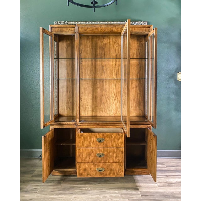 Beautiful 1980s Drexel Heritage “Passage” Collection lighted china cabinet featuring classic campaign hardware, warm wood...