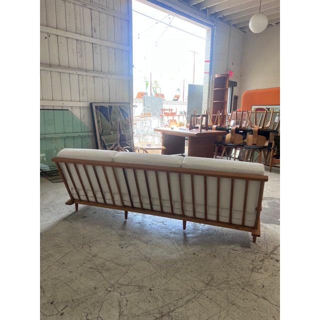 Vintage sofa by Manuel Martin, newly upholstered in a soft textured white fabric, featuring a spindle back beechwood frame...