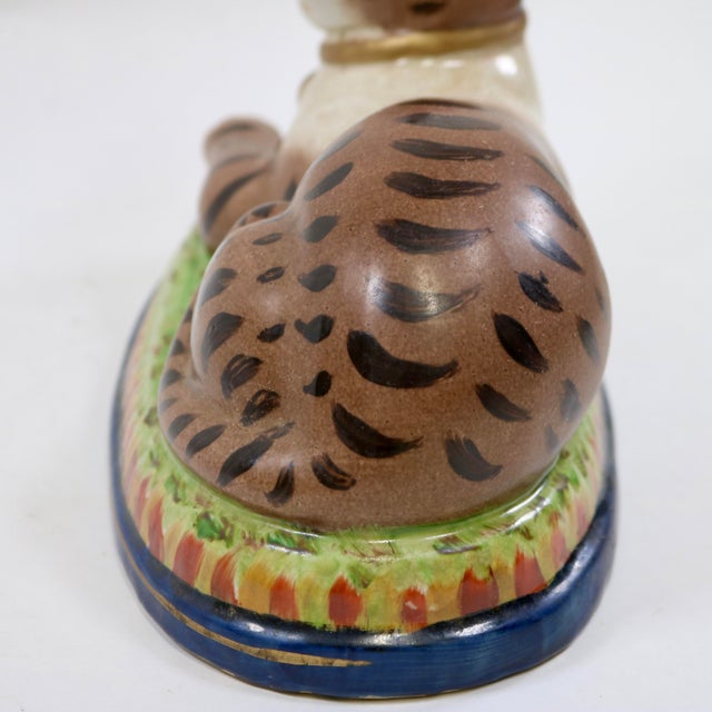 Wonderful recumbent mantle cat painted in folk art whimsical colors. I love the ball in his front paws. Nice large size...