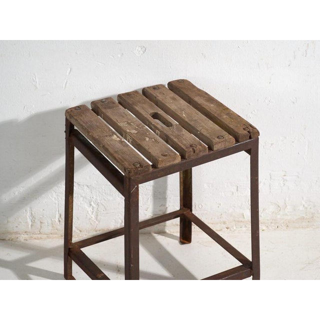 This antique industrial stool in pine wood and iron is an industrial seat with a tubular iron frame and a pine slatted...