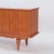 A Mid Century Modern French two door sideboard with exotic satinwood veneers and spade feet ending in brass sabots. C 1960.