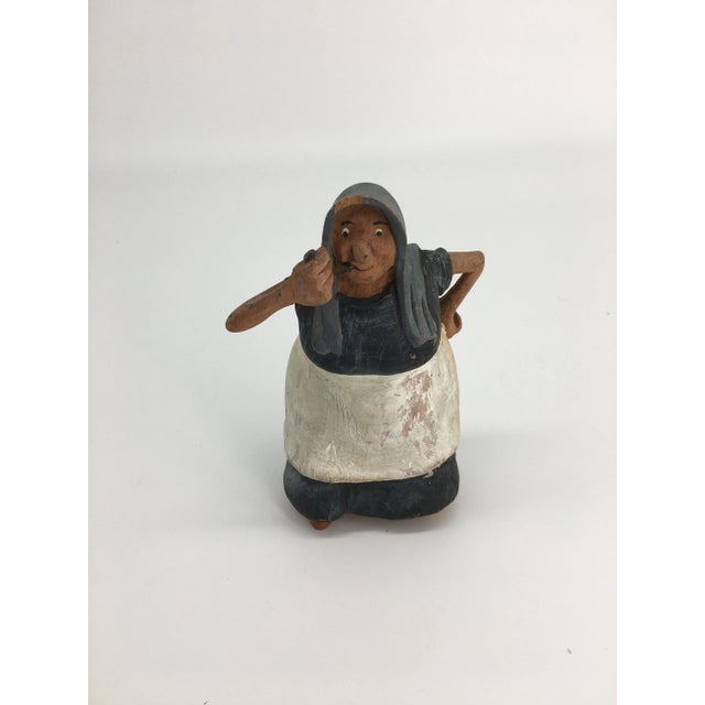 This whimsical carving depicts an old-world European lady smoking her pipe with her hand on her hip. Her expression and...