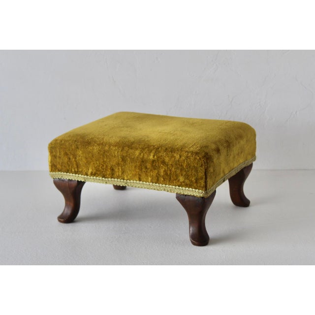 Vintage Queen Anne-style footstool/Ottoman with a mustard-yellow velvet cushion and curved wooden cabriole legs. The...