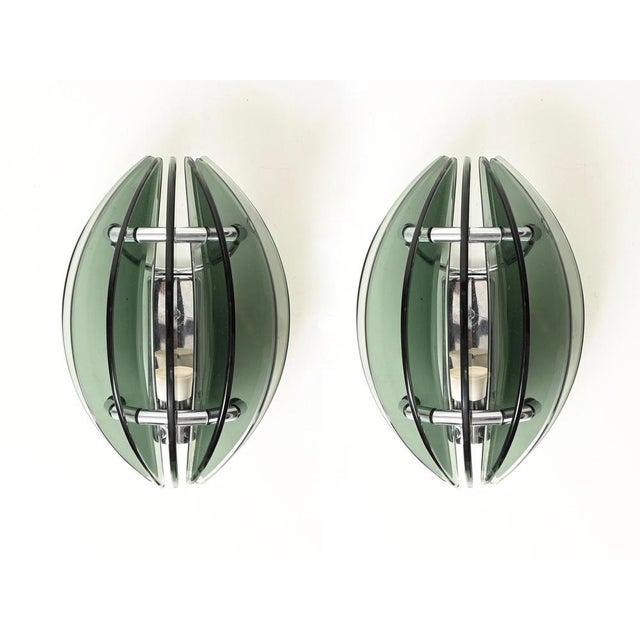 Wonderful and unique pair of mid-century wall sconces in beautiful green crystal glass and chrome-plated metal. These...