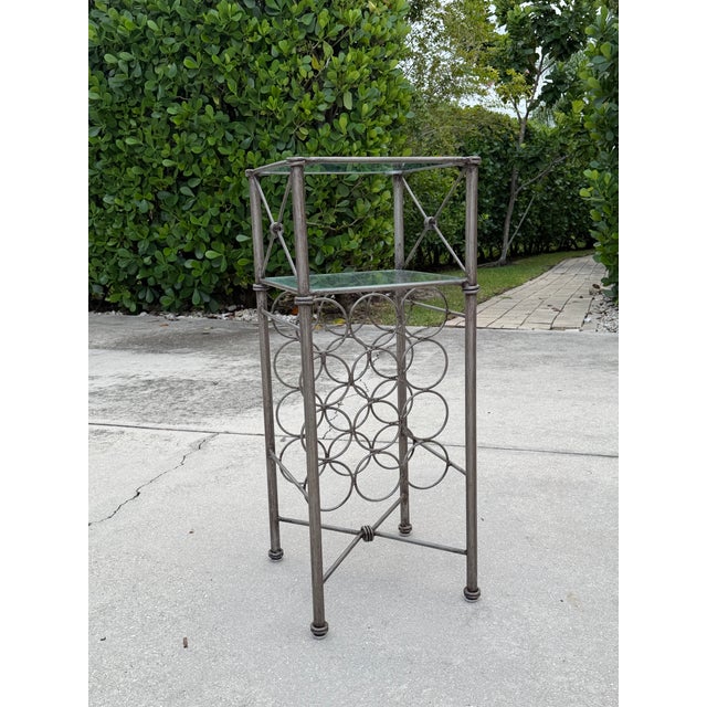 Vintage iron wine rack featuring a sculptural Giacometti-style design with two glass shelves. The open framework...