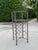 Vintage iron wine rack featuring a sculptural Giacometti-style design with two glass shelves. The open framework...
