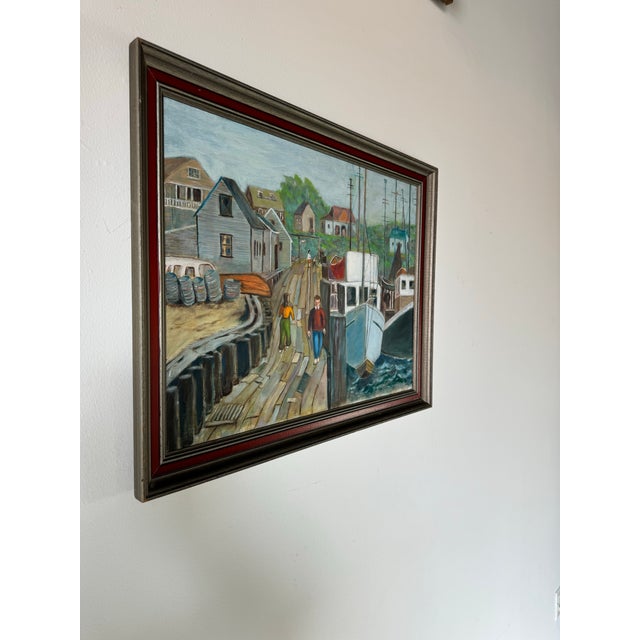 This vintage oil painting presents a lively coastal scene, capturing a harbor filled with fishing boats and the quaint...