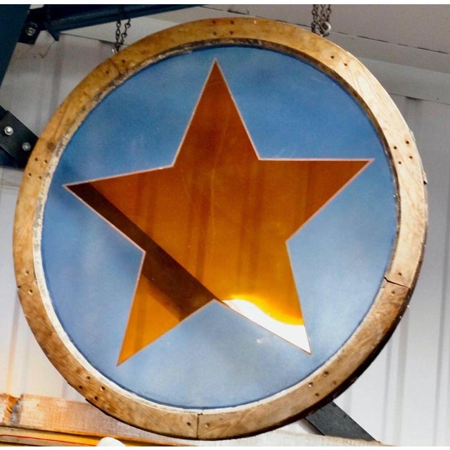 The window incorporates a painted orange glass star motif against a painted blue glass background, all contained within...