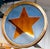 The window incorporates a painted orange glass star motif against a painted blue glass background, all contained within...