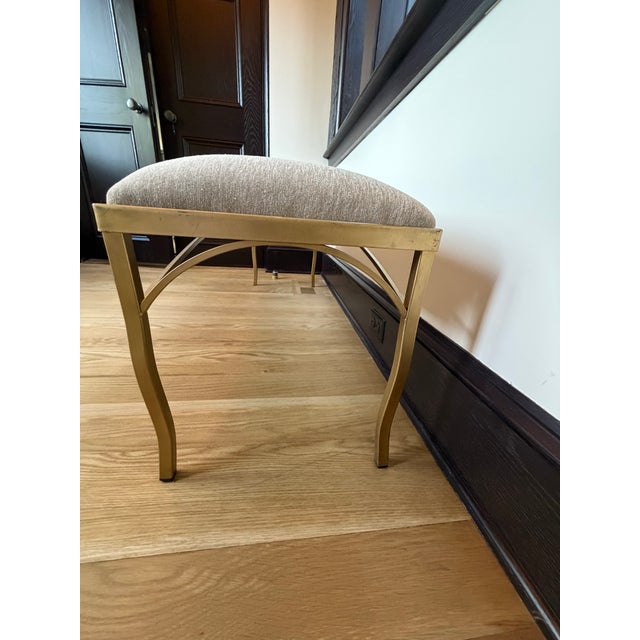 Elegant and versatile, this upholstered bench features a refined brass-finished metal frame with graceful sabre style legs...