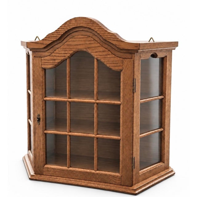 Vintage wall-mounted oak curio cabinet featuring an architectural arched crown, divided transparent panels, angled sides,...
