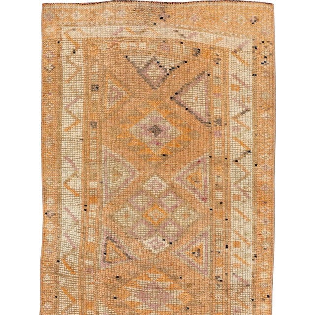 This mid-20th-century Turkish Anatolian runner presents an elongated sequence of geometric medallions arranged across a...