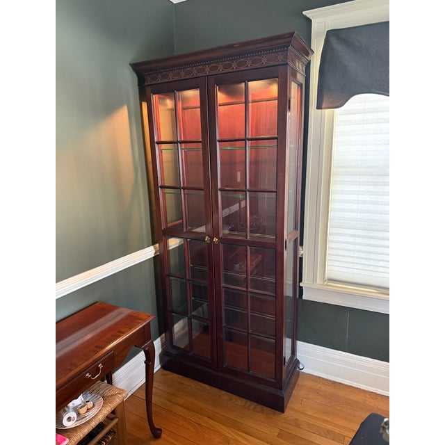 Stunning vintage mahogany curio cabinet attributed to Hickory Chair. The curio cabinet is lit with plug in cord, has...