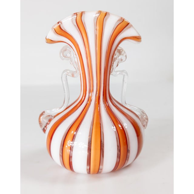 We are selling this miniature Italian Murano glass vase. This vase has cased white and orange banded latticino style...