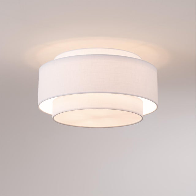 The Coronado 7.5" Flush Mount Kit is a contemporary ceiling light featuring a drum-shaped white linen shade and a sleek...