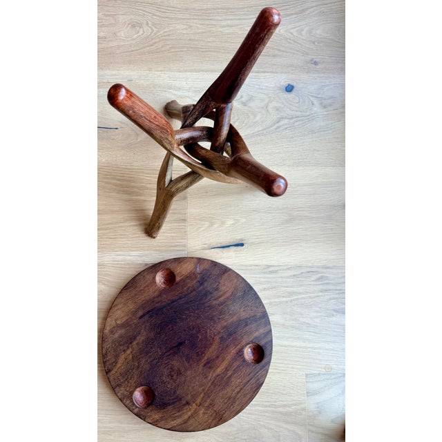 Striking hand-carved African accent table featuring an intricate sculptural twisted wood base and richly grained circular...