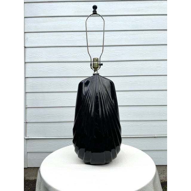 The vintage 1980's Art Deco style lamp reflects a glossy sheen on the heavy embossed black ceramic base. This fixture is...