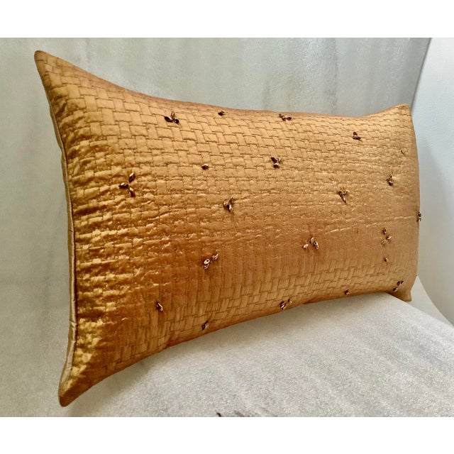 A lush gold hand beaded and quilted silk lumbar pillow cover. It’s hand beaded with glass beads on a basketweave quilted...