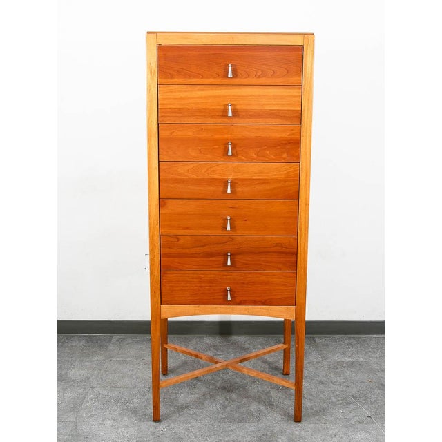 Beautiful tall chest of drawers in cherry wood with metal pulls. Comes with 7 drawers and an x-base frame. Unmarked example.