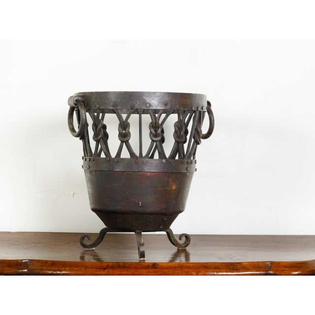 An English metal brazier /pot from the mid 20th century, with knotted motifs and scrolling feet. Created in England during...