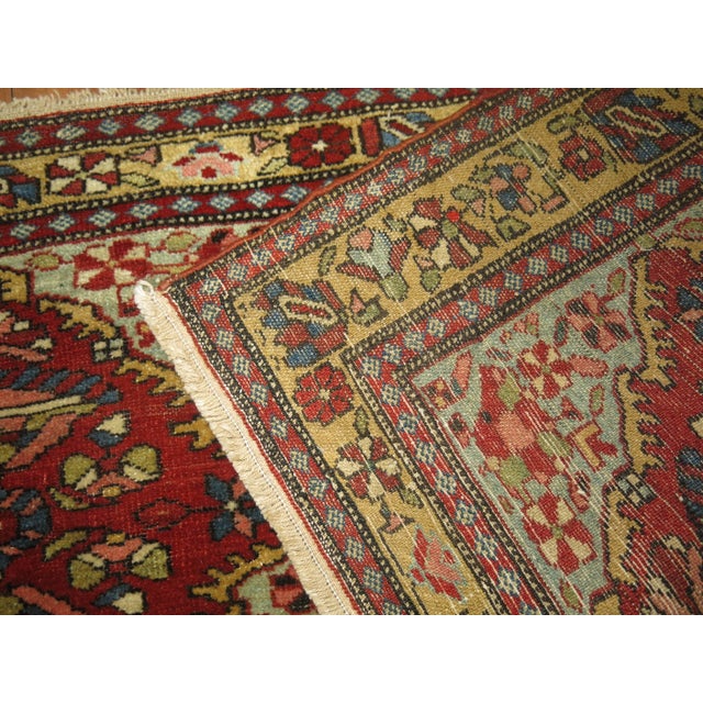 An early 20th century horizontally handwoven Persian Malayer rug with a green field, accents in red and gold Measures:...