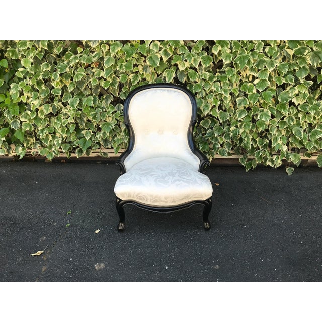 A French Napoleon III slipper chair, mid-to late 19th-century. Carved wood with black lacquer. Newly reupholstered in...