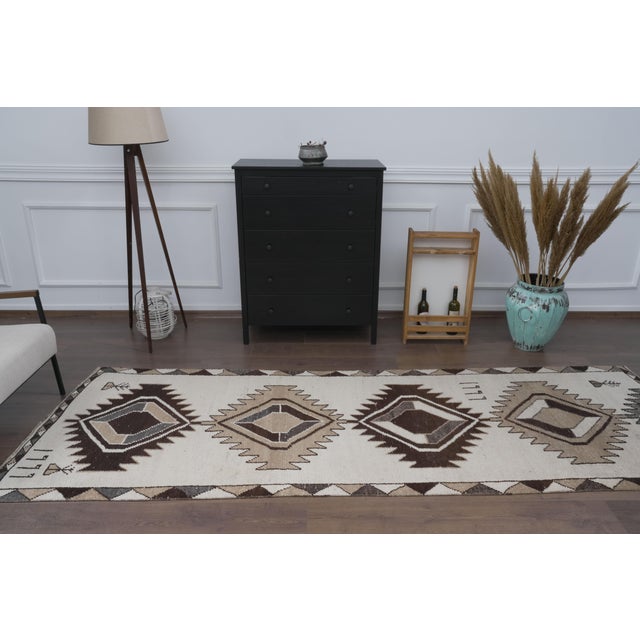 Elevate your hallway, entry, or gallery space with this authentic 1960s vintage handwoven wool runner rug. Woven with a...