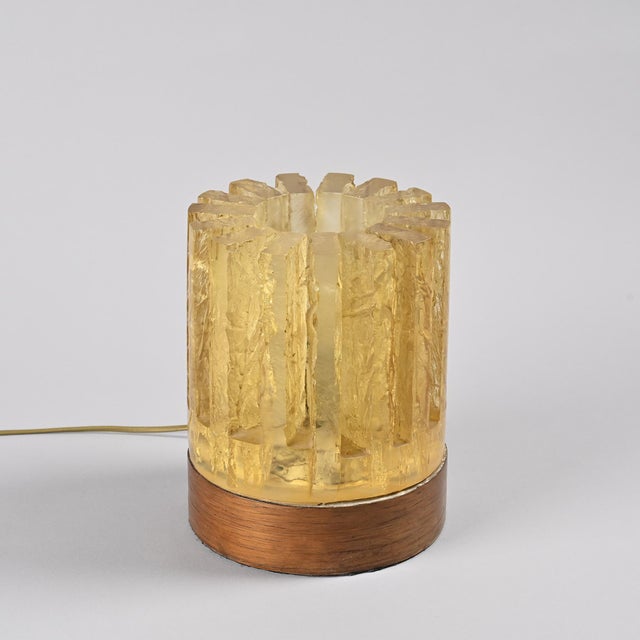 Cylindrical table lamp composed of textured, translucent resin elements, reminiscent of blocks of ice arranged in a...