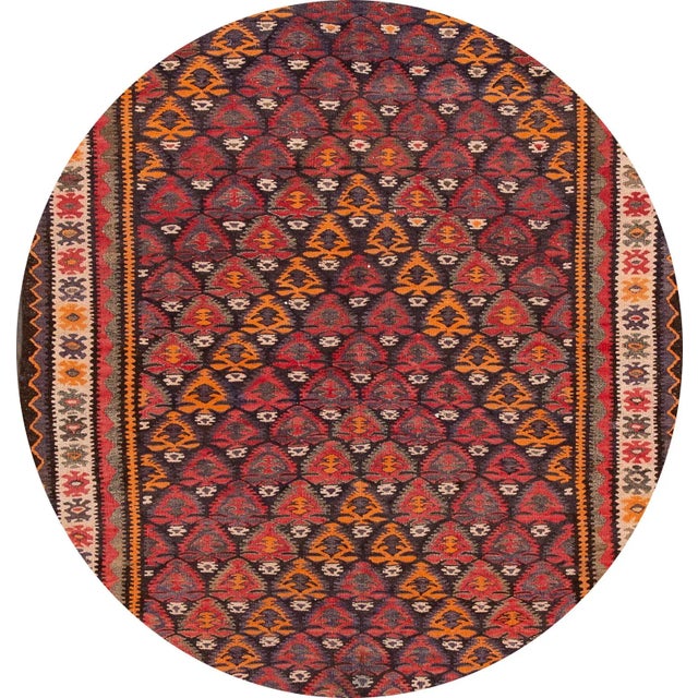 A beautiful hand-woven vintage kilim rug with a red field, and multi-color accents in an all-over geometric design. This...