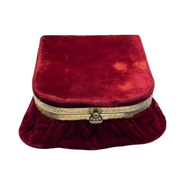 An elegant antique French jewelry casket upholstered in rich ruby red velvet and finished with an engraved metal frame and...