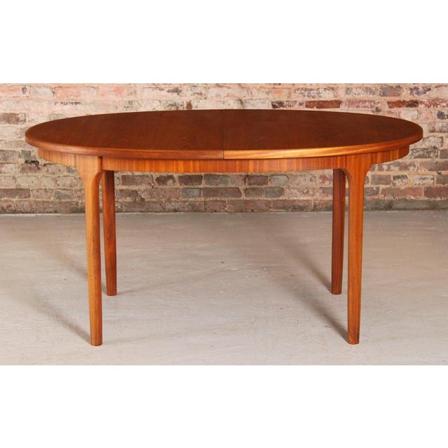 Mid century oval extending teak dining table by mcintosh, circa 1960s. A butterfly extension leaf stored underneath....