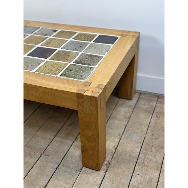 Brutalist coffee table in solid elm with a vintage Maison Regain ceramic stoneware top, circa 1970. Each tile is unique,...