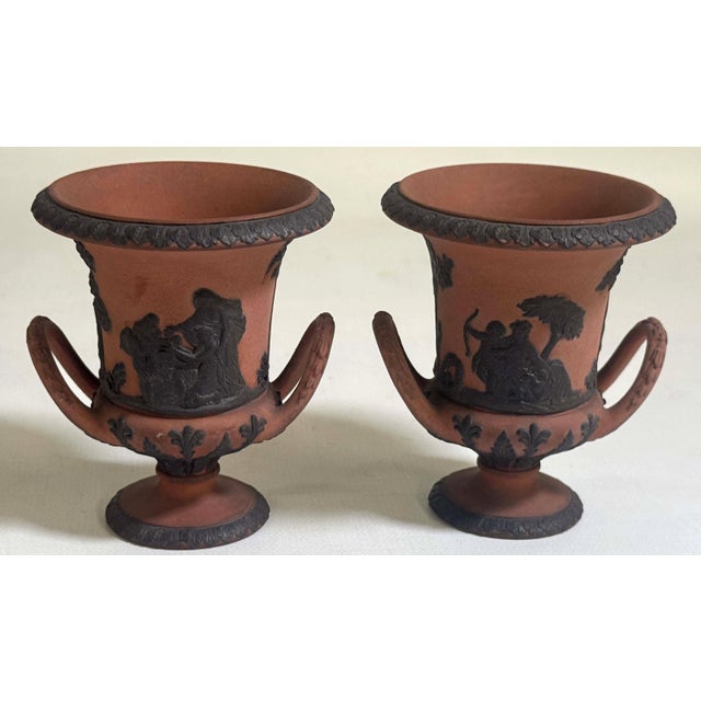 Pair antique 19th century miniature Wedgwood rosso antico & basalt urns or handled vases. Decorated with four classical...