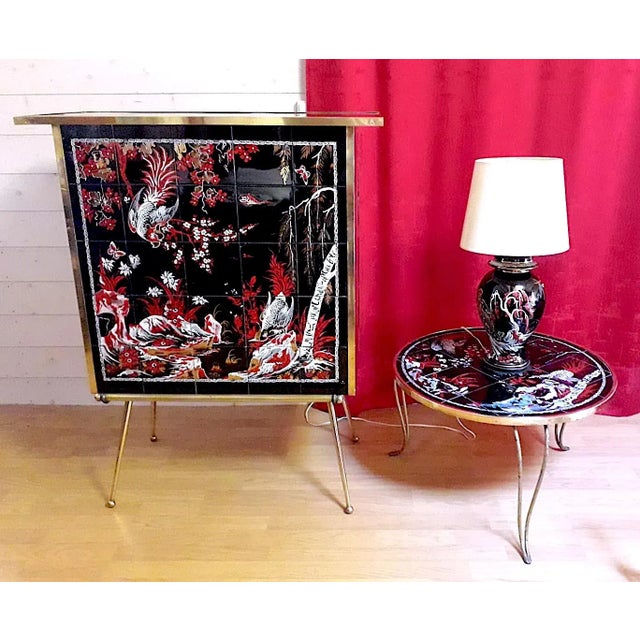 Mid-century dry bar with painted ceramic Asian decor. The bar is signed by the artist DBX France. The painting presents...