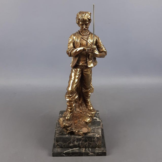 Fantastic vintage collectible sculpture, depicting a fisherman, made of resin agglomerate with golden patina on a marble...