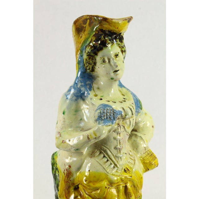 An UNUSUAL early glazed terracotta figurine It depicts a girl or young woman in somewhat pastoral attire, Provençal...