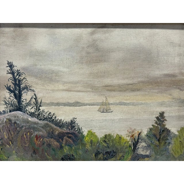 Early 20th-century oil on board coastal landscape depicting a tranquil shoreline scene with a sailboat drifting across...