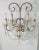 A pair of semi antique wall sconces in the manner of Maison Baguès. Each sconce has five candle style lightbulb holders...