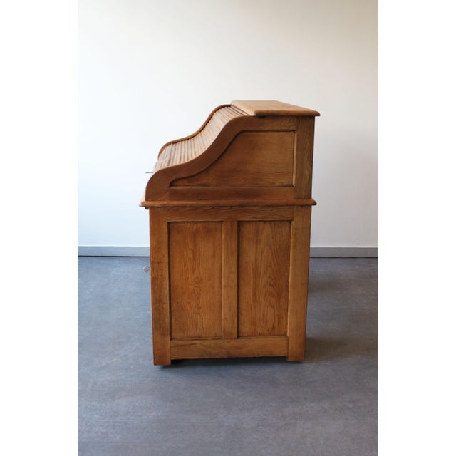 Authentic 1893 roll-top desk with a functional and understated design. A sliding tambour door reveals an organized tiered...