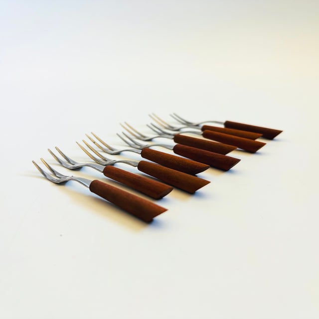 A set of 9 mid century cocktail forks. Each is made of stainless steel with wood handles. Perfect for using as appetizer...