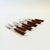 A set of 9 mid century cocktail forks. Each is made of stainless steel with wood handles. Perfect for using as appetizer...