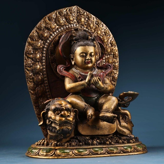 This intricately cast bronze sculpture depicts Manjushri Bodhisattva, the bodhisattva of wisdom, seated gracefully atop a...