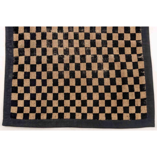Tibetan Black and Tan Checkerboard Prayer Rug. 3' 5" L x 2' 8" W. Provenance: From the Estate of Joseph Lawrence Gardella.