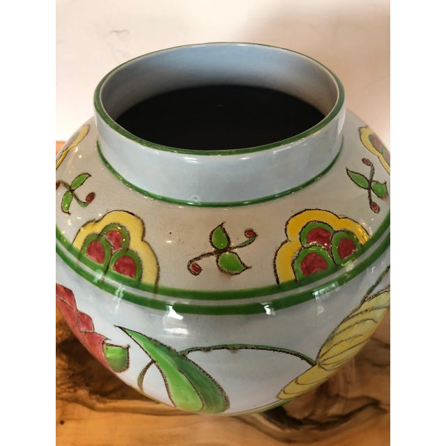 Two nice sized beautifully decorated flowerpots having yellow, raspberry, and green against a very pale grey background...